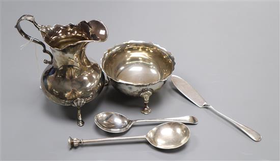 A Victorian silver cream jug, London, 1844, a later silver sugar bowl and three items of silver flatware.